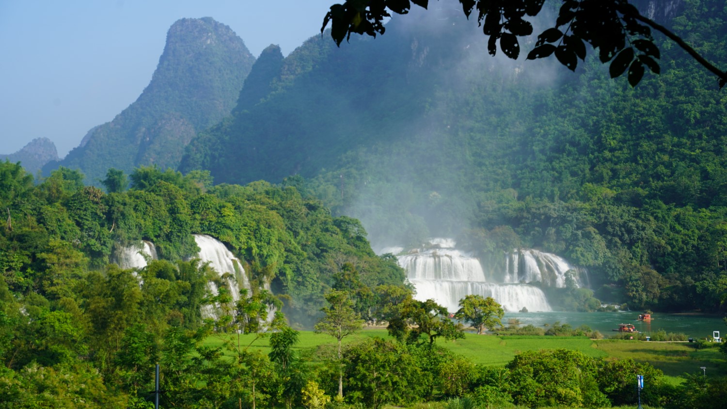 Ban Gioc Waterfall Vietnam, cascading water over limestone cliffs, lush green surroundings, Quay Son River, scenic nature
